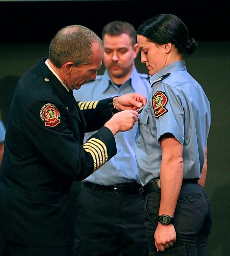 BORIS MINKEVICH / WINNIPEG FREE PRESS
FIRE GRAD 1801 - WFPS Chief John Lane attaches badge #2500 to grad Katy Butland at The Metropolitan Entertainment Centre this afternoon. 16 new recruits graduated today. April 13, 2018