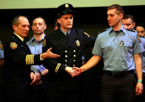 BORIS MINKEVICH / WINNIPEG FREE PRESS
FIRE GRAD 1801 - From left, WFPS Chief John Lane watches WFPS retired firefighter Gary Oakley present his son Ted with his badge #2501 at The Metropolitan Entertainment Centre this afternoon. 16 new recruits graduated today. April 13, 2018