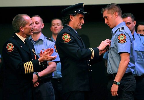 BORIS MINKEVICH / WINNIPEG FREE PRESS
FIRE GRAD 1801 - From left, WFPS Chief John Lane watches WFPS retired firefighter Gary Oakley present his son Ted with his badge #2501 at The Metropolitan Entertainment Centre this afternoon. 16 new recruits graduated today. April 13, 2018