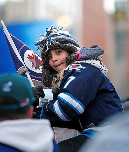 PHIL HOSSACK / WINNIPEG FREE PRESS -Rylan Pries waved the team flag from on top of her cousin's shoulders as she took in the festivities on Donald Street Friday. Stand-Up - April 13, 2018