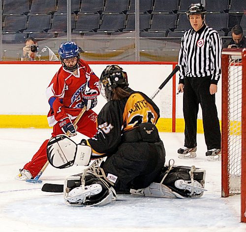 PHIL HOSSACK / WINNIPEG FREE PRESS - Calgary Under 16 #3 Halee Parsons homes in on Manitoba Under 16 goalie #35 Julianna McIntyre Saturday morning in playoff action at the Bell/MTS Centre. See story. - April 14, 2018

