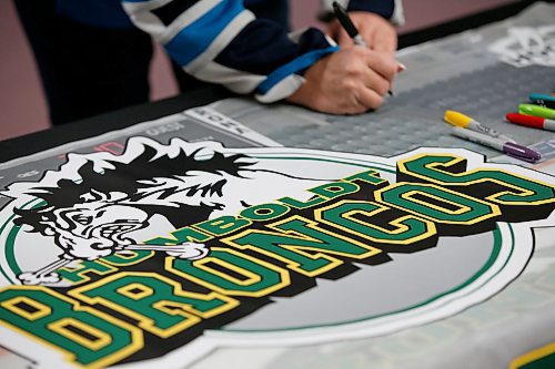 JOHN WOODS / WINNIPEG FREE PRESS
A person signs a banner at a Manitoba Hockey vigil for the Humboldt Broncos at My Church in Winnipeg Monday, April 16, 2018.