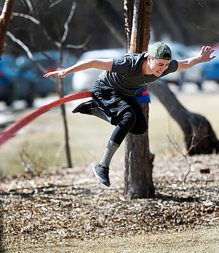 PHIL HOSSACK / WINNIPEG FREE PRESS - STAND-UP- Josh Hutton took advantage of a day off work (and double digit temperatures for the first time since October last year) to hone his slack line walk in Assinaboine Park Tuesday. - April 17, 2018