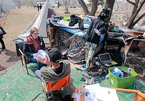 BORIS MINKEVICH / WINNIPEG FREE PRESS
A Street Census of homeless Winnipeggers was done today. This photo was taken in the park at the corner of Higgins and Main. Here volunteer Heather Campbell-Enns, left, interviews a homeless person at a makeshift camp in the back corner of the park near the tracks. April 18, 2018