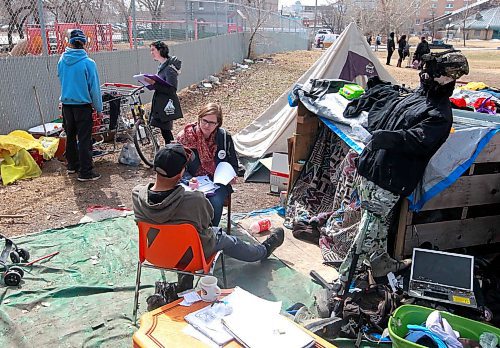 BORIS MINKEVICH / WINNIPEG FREE PRESS
A Street Census of homeless Winnipeggers was done today. This photo was taken in the park at the corner of Higgins and Main. Here volunteer Heather Campbell-Enns, right sitting down, interviews a homeless person while Lisa Manning, behind left, interviews another homeless person. This was in a makeshift shanty camp in the back corner of the park near the train tracks. April 18, 2018