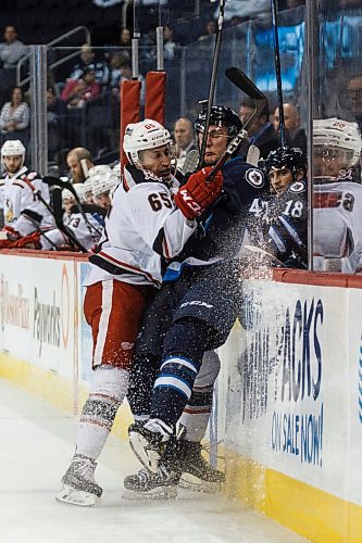 MIKE DEAL / WINNIPEG FREE PRESS
Manitoba Moose Peter Stoykewych (42) is checked by Grand Rapids Griffins Dominik Shine (65) during the second period of game 1 of the first round in the AHL playoffs at Bell MTS Place Saturday afternoon.
180421 - Saturday, April 21, 2018.