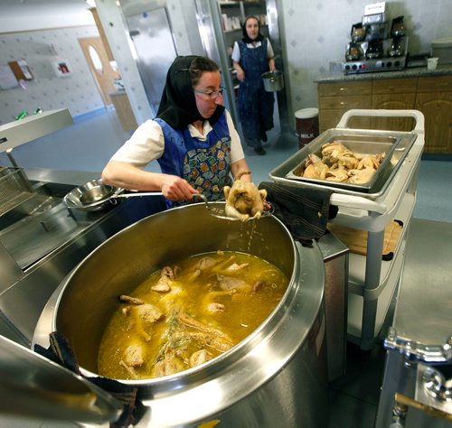 PHIL HOSSACK/Winnipeg Free Press - Melissa Hofer removes cooked chicken from a huge soup pot at the James Valley Hutterite Colony community kitchen Tuesday.   One of the original Hutterite settlements in Manitoba the James Valley community celebrates it's 100th Anniversary this year.  -  April 24, 2018