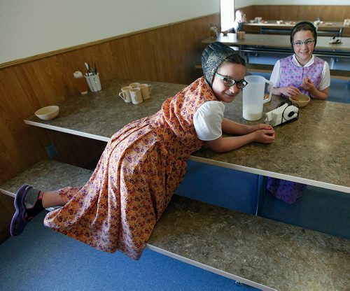 PHIL HOSSACK/Winnipeg Free Press - Hannah,(left) and Gloria, an elementary student at the James Valley Hutterite Colony settles into her lunch in the children's dining room Tuesday. Children from the age of 5 -15 eat separately from their parents who dine in a separate room at the community's main kitchen hall.  James Valley Hutterite Colony home.  One of the original Hutterite settlements in Manitoba the James Valley community celebrates it's 100th Anniversary this year.  -  April 24, 2018