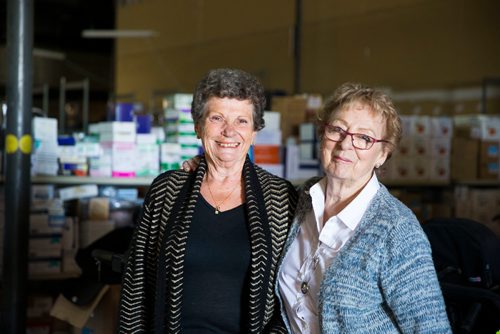 MIKAELA MACKENZIE / WINNIPEG FREE PRESS
Valerie McIntyre (left) and Roma Maconachie, longtime volunteers with International Hope, a nonprofit that provides medical supplies to impoverished countries, pose in the warehouse in Winnipeg on Thursday, April 26, 2018. 
Mikaela MacKenzie / Winnipeg Free Press 2018.