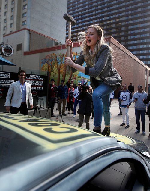 PHIL HOSSACK / WINNIPEG FREE PRESS - Rebecca Dahl aims a 9 pound hammer at a derelect car at a downtown eatery Friday evening. Carbone Pizza  organized the charitable "Take a hammer and hit a car" event. See release? STAND-UP. - April 27, 2018
