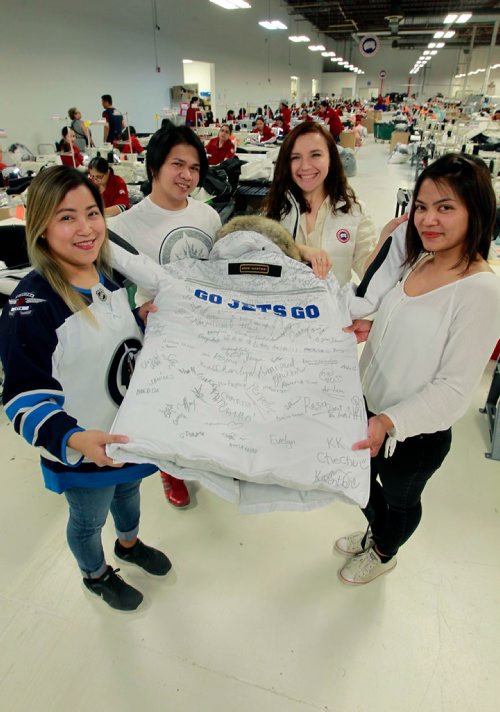 BORIS MINKEVICH / WINNIPEG FREE PRESS
From left, Graceilla Escano, Jayson Dogillo, Olga Fedus, and Geraldine Desepeda hold up a custom made Canada Goose "Snow Mantra" parka that will be presented to Winnipeg Mayor Brian Bowman Thursday morning at City Hall. The custom jacket has GO JETS GO in the back and was signed by Canada Goose employees in the Winnipeg sewing factory at 1455 Mountain Ave. Photo taken on the shop floor. STANDUP PHOTO May 1, 2018
