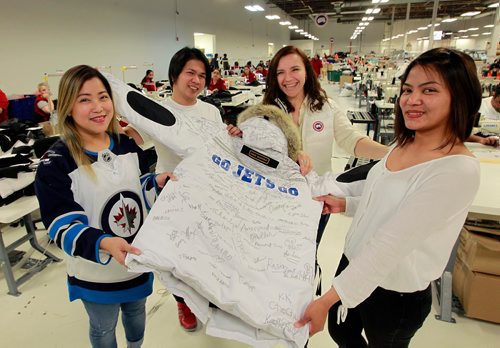 BORIS MINKEVICH / WINNIPEG FREE PRESS
From left, Graceilla Escano, Jayson Dogillo, Olga Fedus, and Geraldine Desepeda hold up a custom made Canada Goose "Snow Mantra" parka that will be presented to Winnipeg Mayor Brian Bowman Thursday morning at City Hall. The custom jacket has GO JETS GO in the back and was signed by Canada Goose employees in the Winnipeg sewing factory at 1455 Mountain Ave. Photo taken on the shop floor. STANDUP PHOTO May 1, 2018