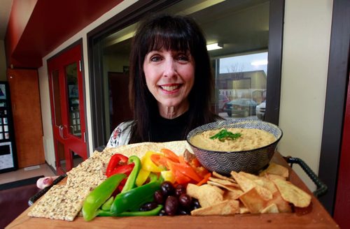 BORIS MINKEVICH / WINNIPEG FREE PRESS
INTERSECTION - Mary MacLean runs a business called Happy Dance Hummus. May 13 is International Hummus Day. MacLean is a school teacher who launched her own hummus business three years ago. Here she shows a plate featuring her home made product. Photo taken at 851 Panet Road where her commercial kitchen is located. DAVE SANDERSON STORY May 1, 2018