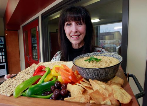 BORIS MINKEVICH / WINNIPEG FREE PRESS
INTERSECTION - Mary MacLean runs a business called Happy Dance Hummus. May 13 is International Hummus Day. MacLean is a school teacher who launched her own hummus business three years ago. Here she shows a plate featuring her home made product. Photo taken at 851 Panet Road where her commercial kitchen is located. DAVE SANDERSON STORY May 1, 2018