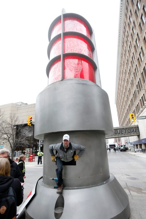 PHIL HOSSACK / WINNIPEG FREE PRESS - STREET PARTY - John Molinski crawls out from the inside of the giant goal light on Donald Street at Graham preparing it for the Jets Whiteout Party Tuesday.   Jessica's story.  - May 1, 2018