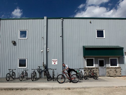 PHIL HOSSACK / WINNIPEG FREE PRESS - Timothy Kleinsasser climbs onto his bicycle for the short commute from the Crystal Springs manufacturing plant to home at coffee time. Bicycles formerly banned in Huttarian communities are common place at Crystal Springs.  Bill Redekop's story.  - May 2, 2018