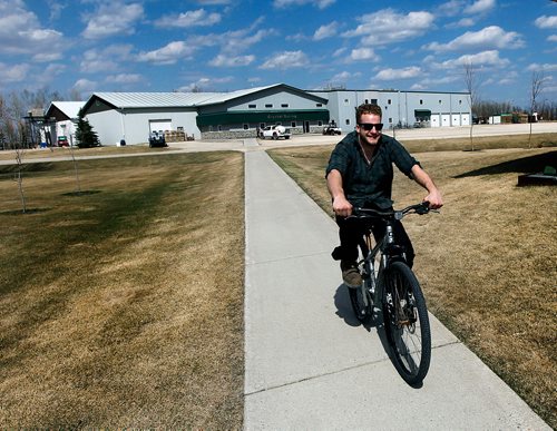 PHIL HOSSACK / WINNIPEG FREE PRESS - Neil Kleinsasser climbs rides his bicycle for the short commute from the Crystal Springs manufacturing plant to home at coffee time. Bicycles formerly banned in Huttarian communities are common place at Crystal Springs.  Bill Redekop's story.  - May 2, 2018