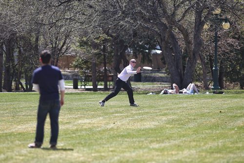 MIKE DEAL / WINNIPEG FREE PRESS
Mario Markmann tosses a frisbee around with a friend during a break at work on the grounds of the Manitoba Legislative Building Monday afternoon as the temperature pushes into the 31C territory. 
180507 - Monday, May 7, 2018.