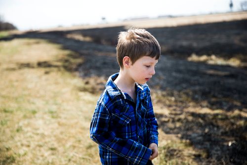 MIKAELA MACKENZIE / WINNIPEG FREE PRESS
Jayden Lepine, seven, takes a look at the sooty mark the grass fire left around the perimeter highway and Roblin Boulevard in Winnipeg on Tuesday, May 8, 2018. Community members say neighbourhood kids lit the bike on fire, and the fire rapidly spread.
Mikaela MacKenzie / Winnipeg Free Press 2018.