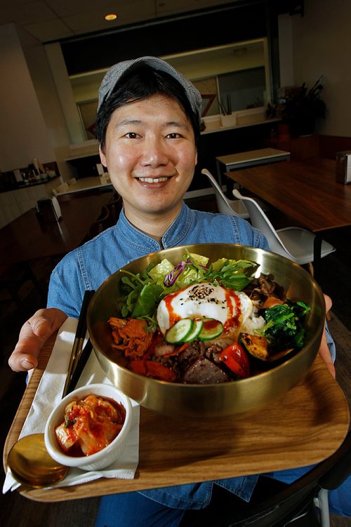 PHIL HOSSACK / WINNIPEG FREE PRESS - Review, Greenish - Owner, chef and husband Yunggi Yoon shows off a house specialty, Bibmbap, Sesame, Chili Sauce, quinoa, shitake, vegetables, fried egg kimchi and beef - MAY 11, 2018.