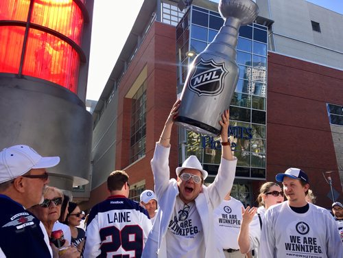 Ruth Bonneville / Winnipeg Free Press 
Brandon Klimenko hoists a fake Stanley Cup on Donald Street at Graham Avenue during the Whiteout street party before the start of Game 1 of the Western Conference final between the Winnipeg Jets and the Las Vegas Golden Knights in Winnipeg, Saturday, May 12, 2018. Klimenko hopes the Jets wins the real one.