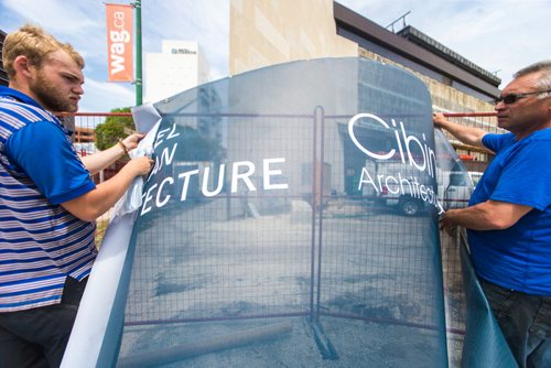 MIKAELA MACKENZIE / WINNIPEG FREE PRESS
Contractors Brick Kroitor (left) and Fyodor Kroitor put signage up on the fences for construction at the Winnipeg Art Gallery's new Inuit Art Centre, which officially breaks ground tomorrow, in Winnipeg on Thursday, May 24, 2018.  
Mikaela MacKenzie / Winnipeg Free Press 2018.