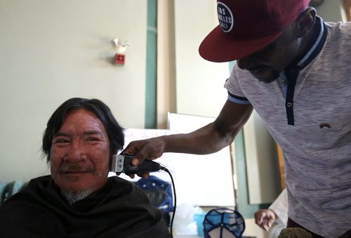 TREVOR HAGAN /  WINNIPEG FREE PRESS
Abdulla Alhassan cuts hair for Richard C earlier today. End Homelessness Winnipeg and the Manitoba Financial Empowerment Network put on a homelessness expo at the Neeginan Centre, Saturday, May 26, 2018.