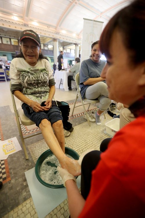 TREVOR HAGAN /  WINNIPEG FREE PRESS
Marjorie Moose has her feet washed and massaged by Isabel Colucci. End Homelessness Winnipeg and the Manitoba Financial Empowerment Network put on a homelessness expo at the Neeginan Centre, Saturday, May 26, 2018.