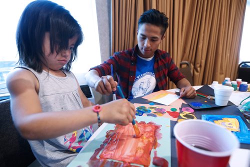JOHN WOODS / WINNIPEG FREE PRESS
M Mawi Wi Chi Itata Centre youth worker Rylee Nepinak paints with Jensie Pascal from Pauningassi in a Winnipeg hotelTuesday, May 29, 2018. The children are in Winnipeg as part of a fire evacuation.

