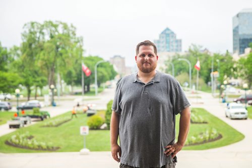 MIKAELA MACKENZIE / WINNIPEG FREE PRESS
Justin Luschinski, who is taking part in Pride this weekend, poses in front of the Manitoba Legislative Building in Winnipeg on Wednesday, May 30, 2018.  
Mikaela MacKenzie / Winnipeg Free Press 2018.