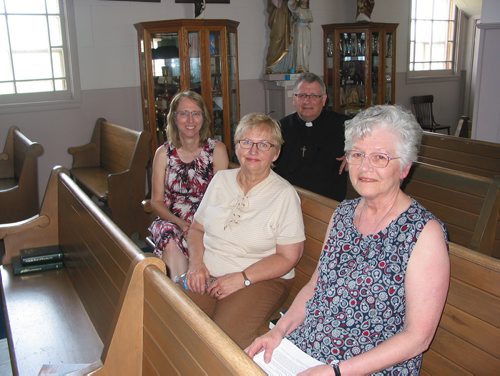 Canstar Community News May 23, 2018 - (From left, front row) St. Francois Xavier Cathoilc Church members Elaine Senecal, Lori Ann Regnier and Odile Thibert and paris priest Father Michel Nault sit in pews inside the church with cabinets of religious artifacts in the background. (ANDREA GEARY/CANSTAR COMMUNITY NEWS)