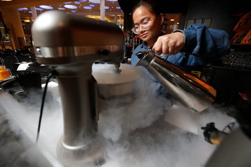 JOHN WOODS / WINNIPEG FREE PRESS
Bartender Princess Camia pours liquid nitrogen to make Maple Bacon ice cream at Flight Club restaurant at the Winnipeg airport Monday, June 4, 2018.