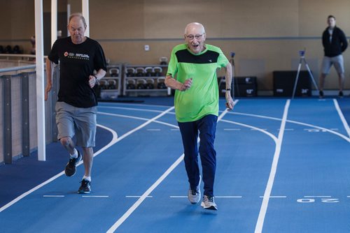 MIKE DEAL / WINNIPEG FREE PRESS
Lou Billinkoff warms up with his trainer Sheldon Reynolds (in black) before he runs the 50 meter dash, which he completed in 14.45 seconds on his 95th birthday at the Canada Games Sport for Life Centre while training for a 100m sprint at the end of June.
180605 - Tuesday, June 05, 2018.