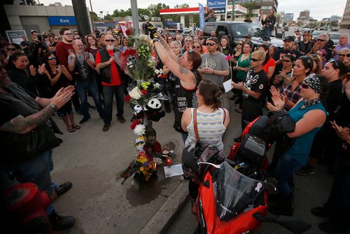 JOHN WOODS / WINNIPEG FREE PRESS
Tamara LeClair places a can on Monster in a memorial with family, friends and supporters gathered at the corner of Portage and Home Tuesday, June 5, 2018 to remember Benson, aka Matt Cave, who was killed in a motorcycle collision with a stolen van.