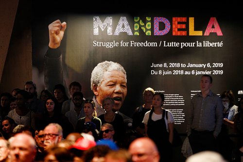PHIL HOSSACK / WINNIPEG FREE PRESS - Spectators at a public event stand in front of the Mandela exhibition entranceway and sign Thursday evening, The first visitors got a glimpse of the Mandela exhibition at the Canadian Museum For Human Rights Thursday evening after a free public event which highlighted the history of the man and the exhibit as well as music and dance by NAfro Dance.. STAND-UP see release.  - June 7, 2018