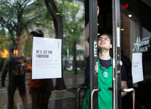 ANDREW RYAN / WINNIPEG FREE PRESS A Starbucks employee locks the door at 2:30 p.m. after the last customers left the location on Broadway. The early closure is part of a continent-wide shut down after a racially insensitive incident drew international attention and prompted racial sensitivity training on June 11, 2018.