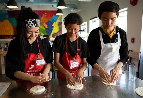 ANDREW RYAN / WINNIPEG FREE PRESS Kayla Umali, left, Erika Yazon, centre, and Winzy Hinsunarin practice kneading pizza dough at the Food Justice Club on June 13, 2018. The Food Justice club at the NorWest Co-op Community Health is lead by chef Camille Metcalf.