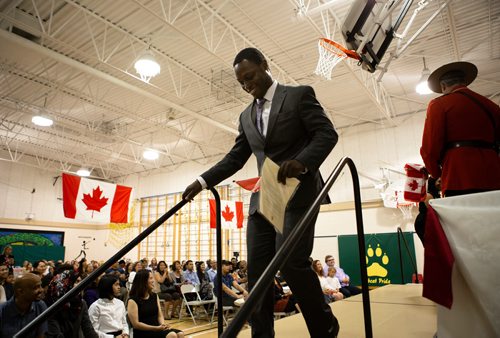 ANDREW RYAN / WINNIPEG FREE PRESS Immigration, Refugees and Citizenship Canada inducted 38 new citizens in a special ceremony held at École Luxton School. A man walks off stage after signing documents and receiving his official document of Canadian citizenship.