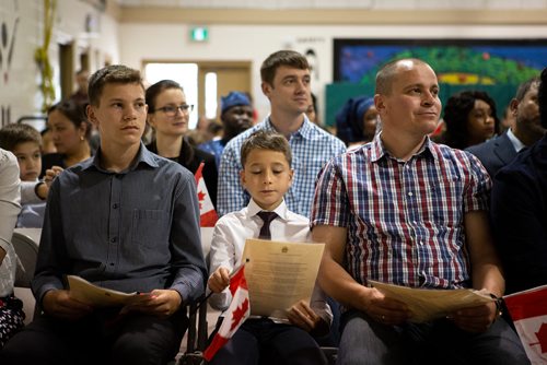 ANDREW RYAN / WINNIPEG FREE PRESS Immigration, Refugees and Citizenship Canada inducted 38 new citizens in a special ceremony held at École Luxton School. Roman Polovinka, 10, checks out his certificate of citizenship with father Igor, right, and older brother Alexander.