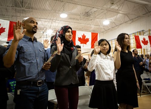 ANDREW RYAN / WINNIPEG FREE PRESS Immigration, Refugees and Citizenship Canada inducted 38 new citizens in a special ceremony held at École Luxton School. Iqra Kahn, second from left, with Ria and Chloë Delos Santos take their oath of Canadian citizenship on June 14, 2018.