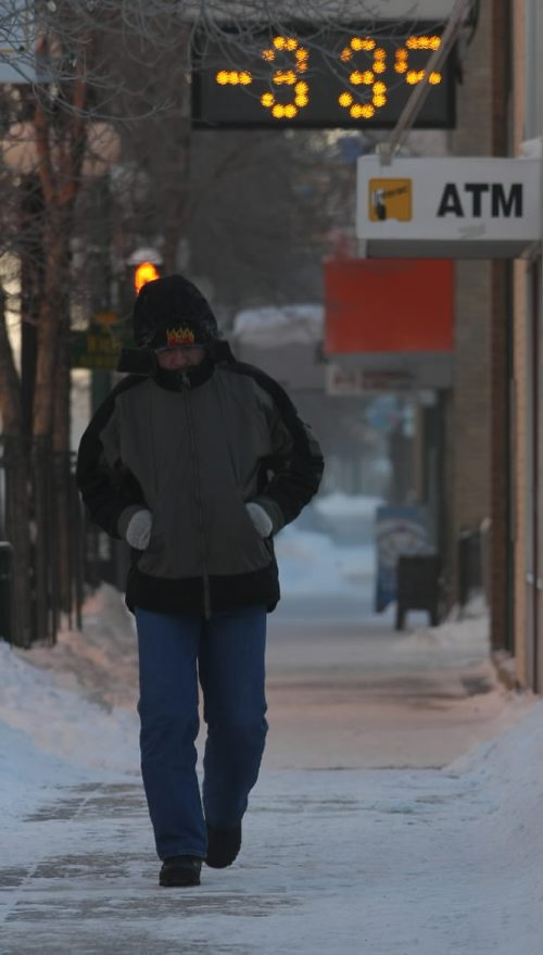 Brandon Sun A pedestrian huddles under his hood as he makes his way along Rosser Avenue in downtown Brandon on Thursday morning. The mercury dipped below -33 C which was compounded by windchill factors reach as low as -48 C. (Bruce Bumstead/Brandon Sun)