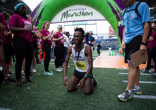 ANDREW RYAN / WINNIPEG FREE PRESS Manitoba half marathon winner Abduselam Yussuf falls to his knees after crossing the finish line with with a time of 1:08:30 on June 17, 2018.