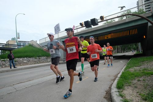 Daniel Crump / Winnipeg Free Press. Pace bunny Jonas Eastcott leads the way for some of the runners like Andrew Butler (79), Cabrel Boucher (128), Jordan Grenier (69) and Greg MacDonald (741) along the course. The 40th Manitoba Marathon, Sunday, June 17, 2018.