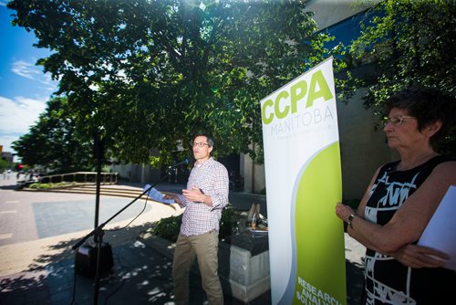 MIKAELA MACKENZIE / WINNIPEG FREE PRESS
Ian Hudson, University of Manitoba economics professor, speaks while organizer Lynne Fernandez watches at the launch of the Winnipeg Alternative Municipal Budget in Winnipeg on Tuesday, June 19, 2018. 
Mikaela MacKenzie / Winnipeg Free Press 2018.