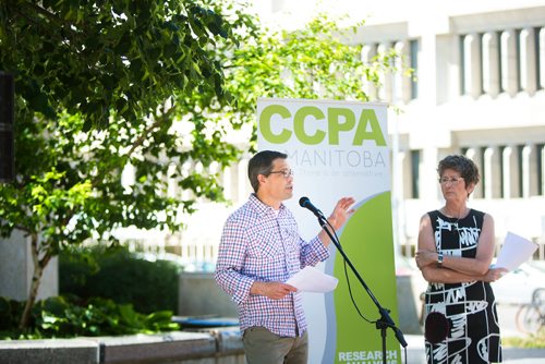 MIKAELA MACKENZIE / WINNIPEG FREE PRESS
Ian Hudson, University of Manitoba economics professor, speaks while organizer Lynne Fernandez watches at the launch of the Winnipeg Alternative Municipal Budget in Winnipeg on Tuesday, June 19, 2018. 
Mikaela MacKenzie / Winnipeg Free Press 2018.