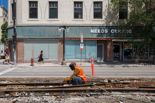 MIKE DEAL / WINNIPEG FREE PRESS
Road construction at Notre Dame Avenue and Arthur Street is taking longer than normal due to the need to remove old street car tracks and cobblestones. 
180619 - Tuesday, June 19, 2018.