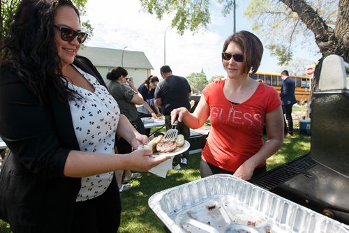 MIKE DEAL / WINNIPEG FREE PRESS
Rachelle Neault (right) a Metis Community Liaison Worker with the MMF prepares smokies and burgers for about sixty people, including Natalie Daniels (left), at a Bar-B-Q to celebrate the 202nd Anniversary of the Victory of Frog Plain, also known as the Battle of Seven Oaks. It was fought as part of the 1816 Pemmican War, where Métis of the North West Company fought and won against Hudson's Bay Company employees and settlers. The battle is considered to be an important historical moment in the creation of the Métis Nation.
180619 - Tuesday, June 19, 2018.