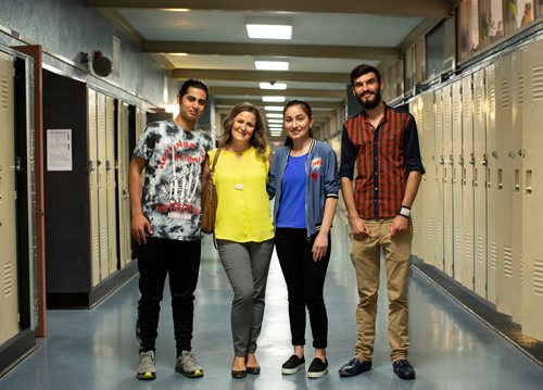 ANDREW RYAN / WINNIPEG FREE PRESS Megan Sodomsky, second from left, is a volunteer English as an Additional Language (EAL) instructor who has helped these three Yazidi refugees adapt to Canadian life. From left is Amin Murad, Megan Sodomsky, Aida Naso, and Diyar Salih at Grant Park High School on June 19, 2018.