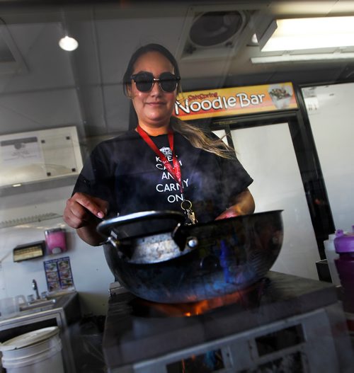 PHIL HOSSACK / WINNIPEG FREE PRESS -Seanna Pascal Stirs up noodles at the Red River Ex Tuesday afternoon. One of a handfull of Carney's who have food booths inder a canopy for shade seeking clients. See Maggie Macintosh's story.- June 19, 2018