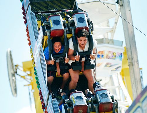 PHIL HOSSACK / WINNIPEG FREE PRESS -The Agony and the "Ex"stacy- A pair of Red River Ex patrons enjoy the midway from different perspectives Tuesday afternoon. See Maggie Macintosh's story.- June 19, 2018